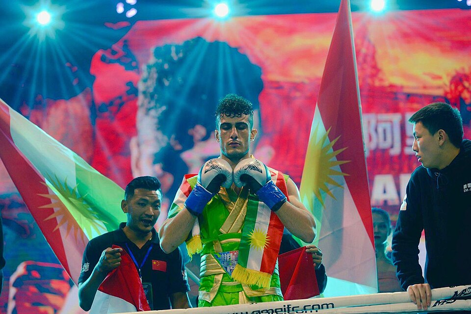 Ali Qaradaghy walking to the ring draped in Kurdistan flags